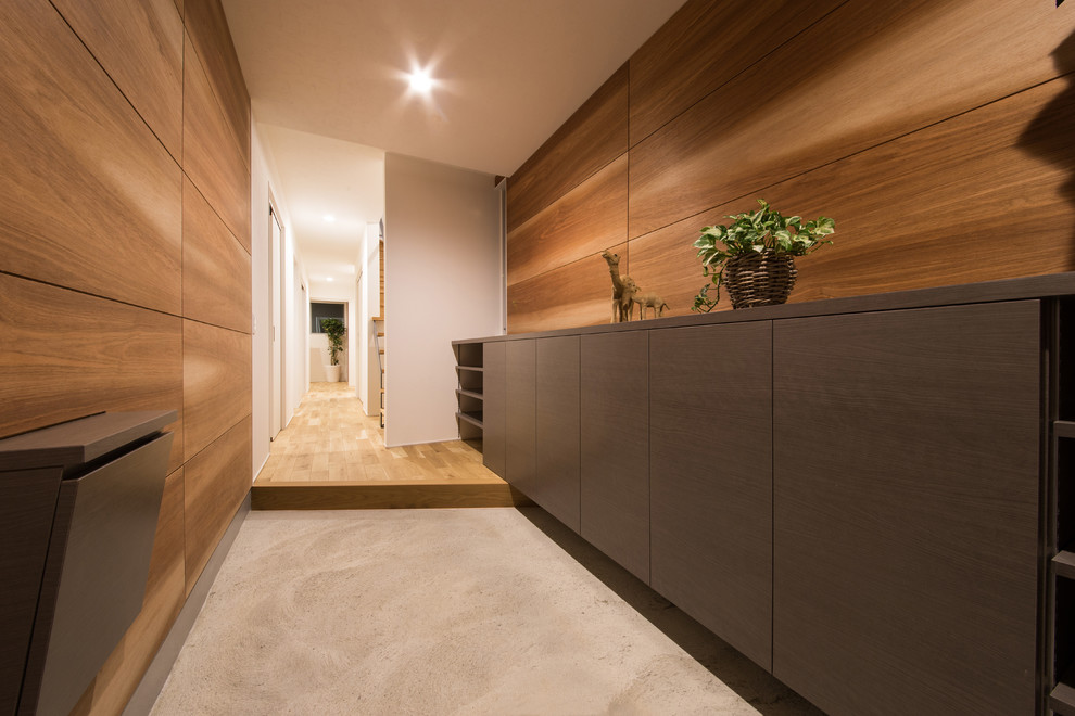 Idee per un ingresso o corridoio minimalista con pareti marroni, pavimento in cemento e pavimento grigio