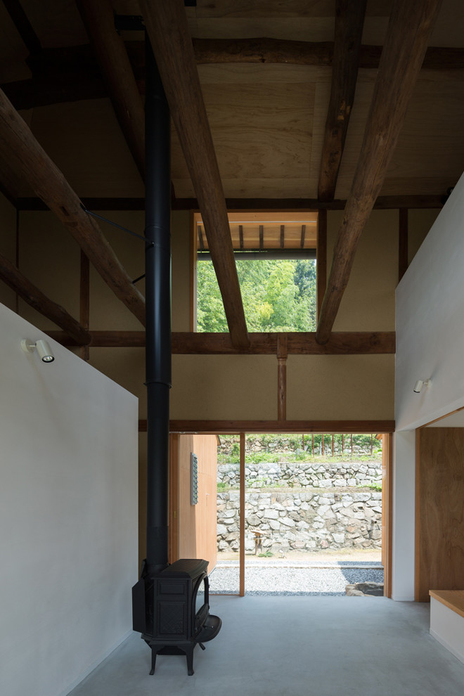 Пример оригинального дизайна: фойе среднего размера в классическом стиле с белыми стенами, бетонным полом, раздвижной входной дверью, входной дверью из светлого дерева, серым полом и балками на потолке