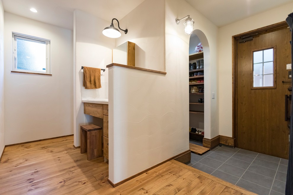 Exemple d'une entrée éclectique avec un couloir, un mur blanc, parquet foncé, une porte simple, une porte en bois foncé et un sol marron.