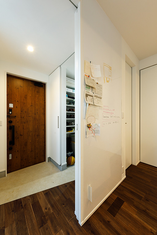 Idéer för mellanstora funkis hallar, med vita väggar, mörkt trägolv, en enkeldörr, en brun dörr och brunt golv