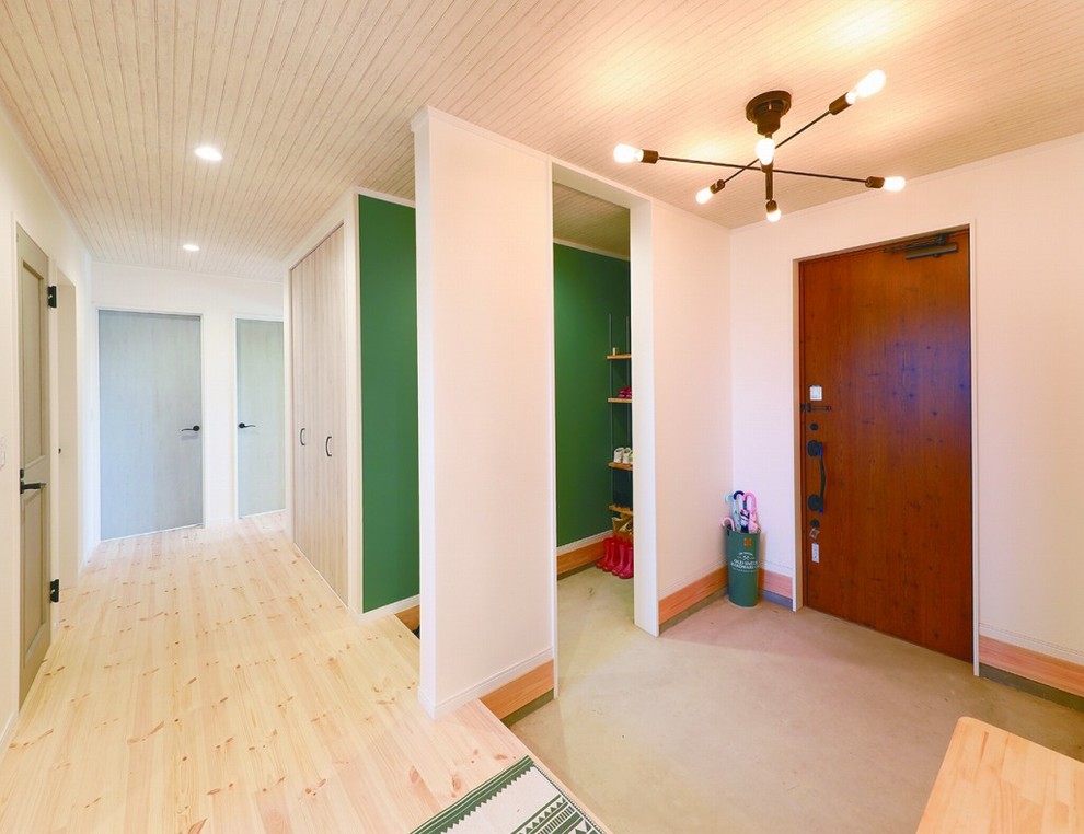 Idee per un corridoio minimalista con pareti bianche, pavimento in cemento, una porta singola, una porta in legno bruno e pavimento grigio