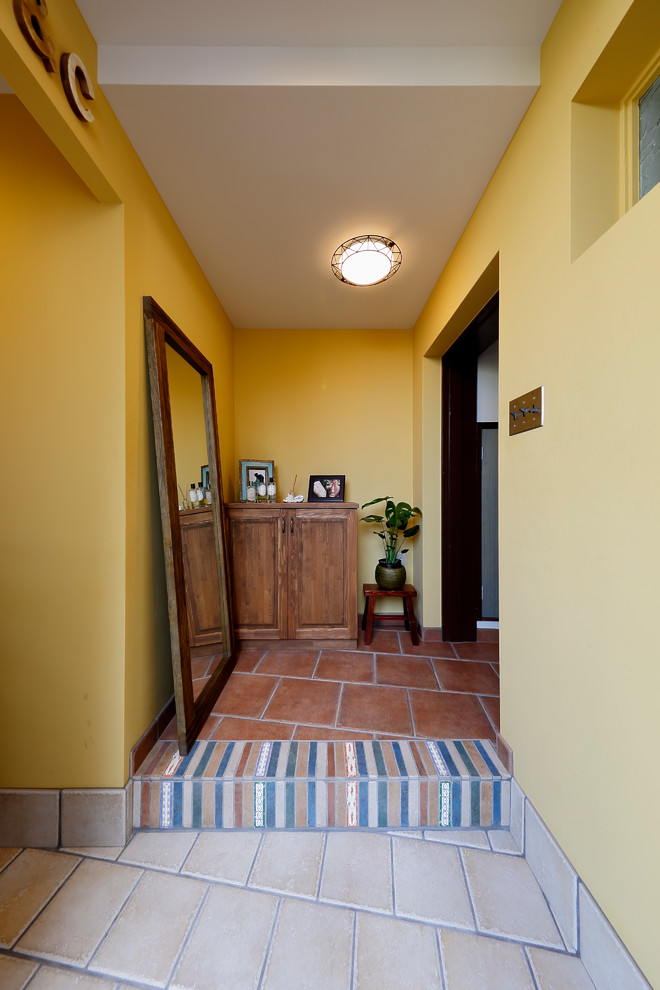 他の地域にある北欧スタイルのおしゃれな玄関 (黄色い壁、ベージュの床) の写真