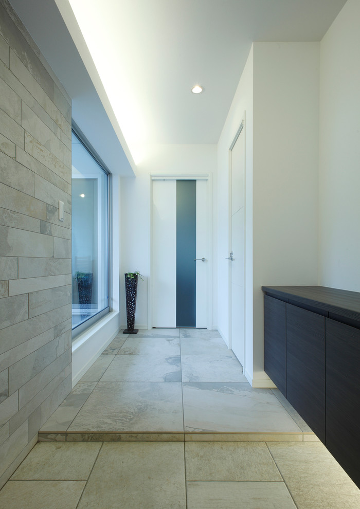 Immagine di un piccolo corridoio moderno con pareti bianche, pavimento con piastrelle in ceramica e pavimento grigio