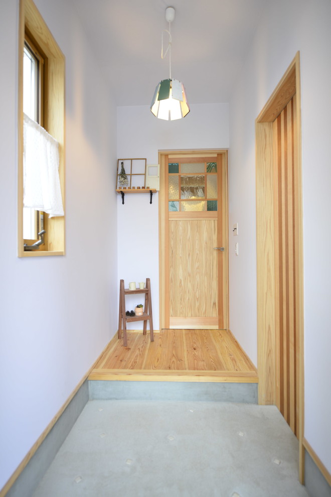 他の地域にあるコンテンポラリースタイルのおしゃれな玄関 (白い壁、コンクリートの床、グレーの床) の写真