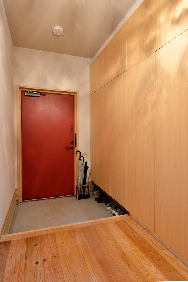 Design ideas for a shabby-chic style hallway in Tokyo with white walls, concrete flooring, a single front door, a red front door and grey floors.
