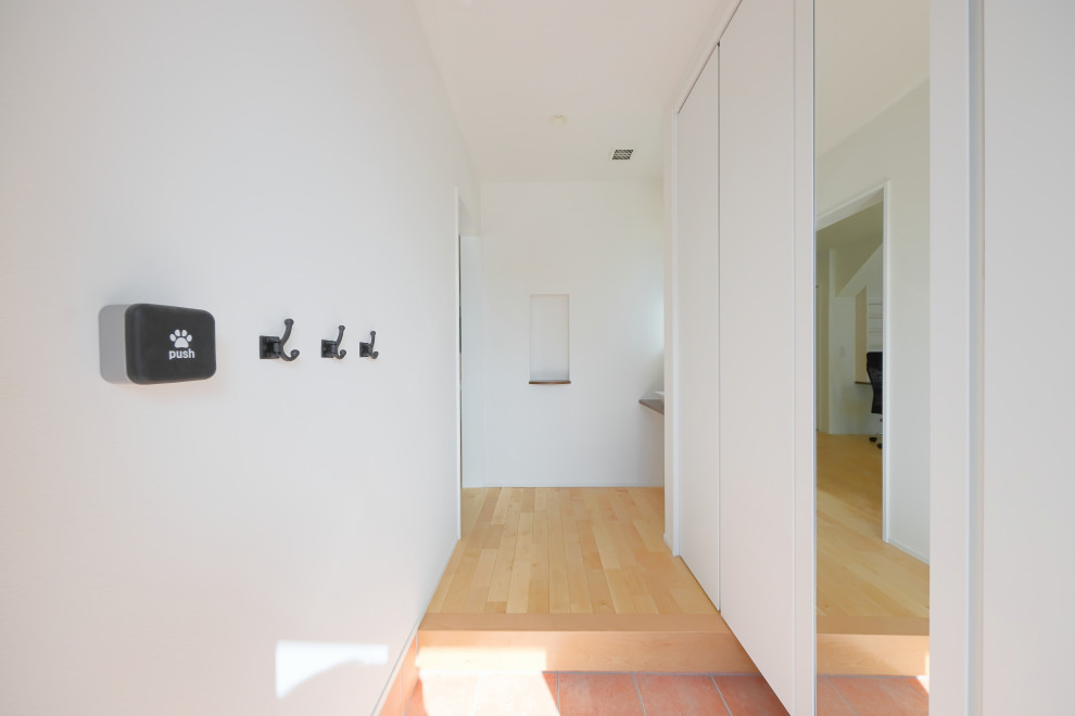 Medium sized contemporary hallway in Nagoya with white walls, light hardwood flooring, a single front door and a medium wood front door.