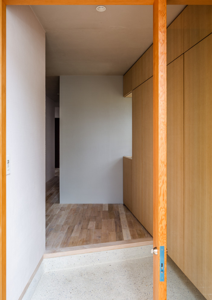 Inspiration pour une porte d'entrée asiatique de taille moyenne avec un mur blanc, une porte simple, une porte en bois brun et un sol blanc.