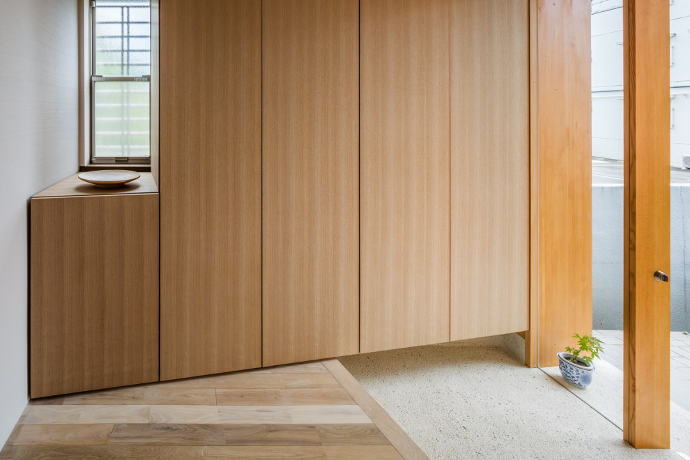 Modelo de puerta principal asiática de tamaño medio con paredes blancas, puerta simple, puerta de madera en tonos medios, suelo de madera clara y suelo beige