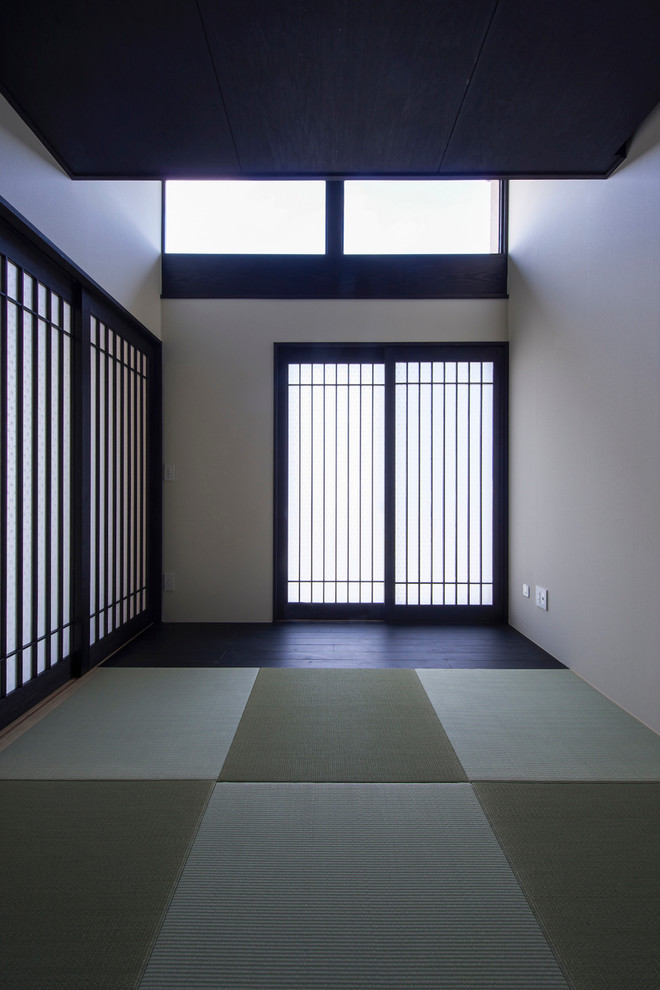 Cette photo montre une entrée asiatique avec un mur blanc, une porte coulissante, un sol de tatami et un couloir.