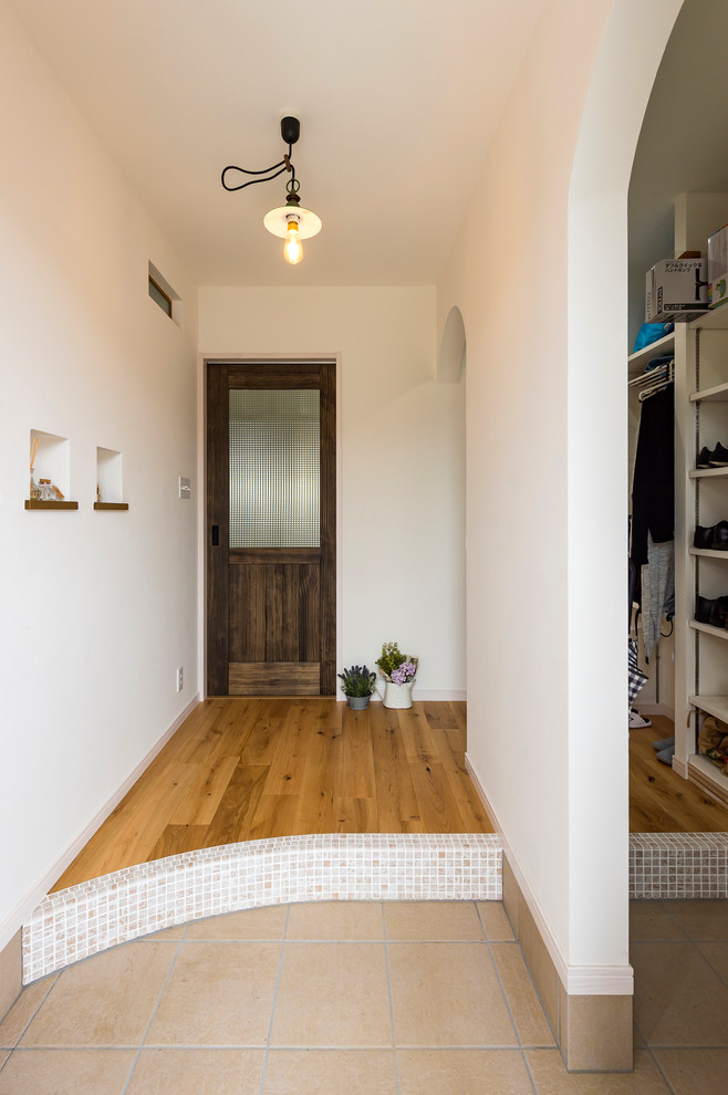 他の地域にあるカントリー風のおしゃれな玄関 (白い壁、セラミックタイルの床、ベージュの床) の写真
