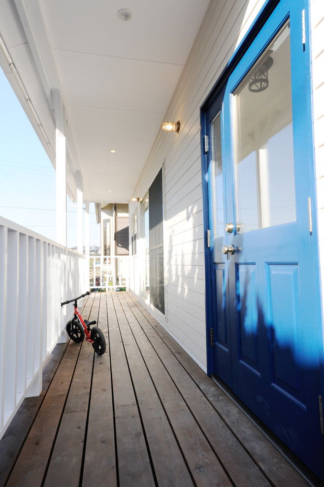 他の地域にあるビーチスタイルのおしゃれな玄関 (白い壁、青いドア) の写真