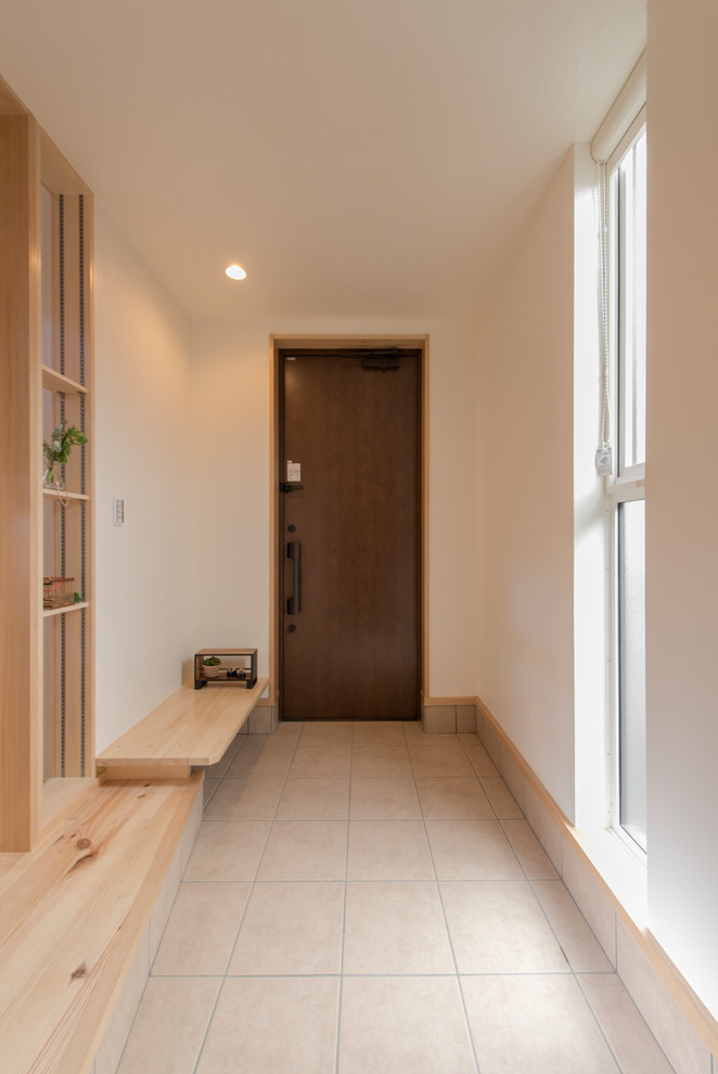 Foto di un corridoio country con pareti bianche, una porta singola, una porta in legno scuro e pavimento beige