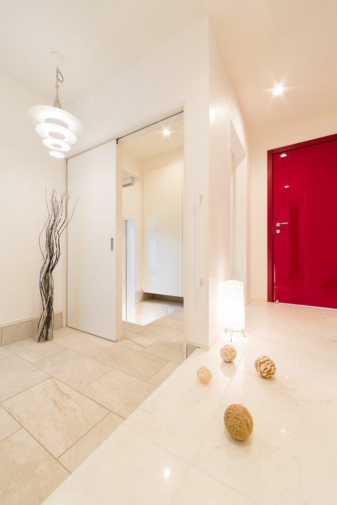 Exempel på en modern entré, med vita väggar, marmorgolv, en enkeldörr, en röd dörr och vitt golv