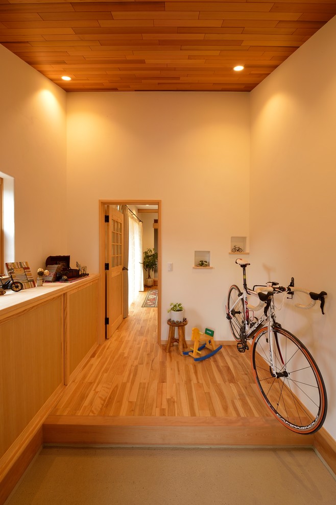 Entryway - scandinavian light wood floor and brown floor entryway idea in Other with beige walls