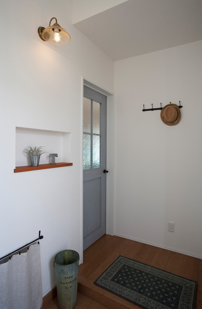 Diseño de hall escandinavo con paredes blancas, suelo de contrachapado, puerta simple, puerta de madera en tonos medios y suelo marrón