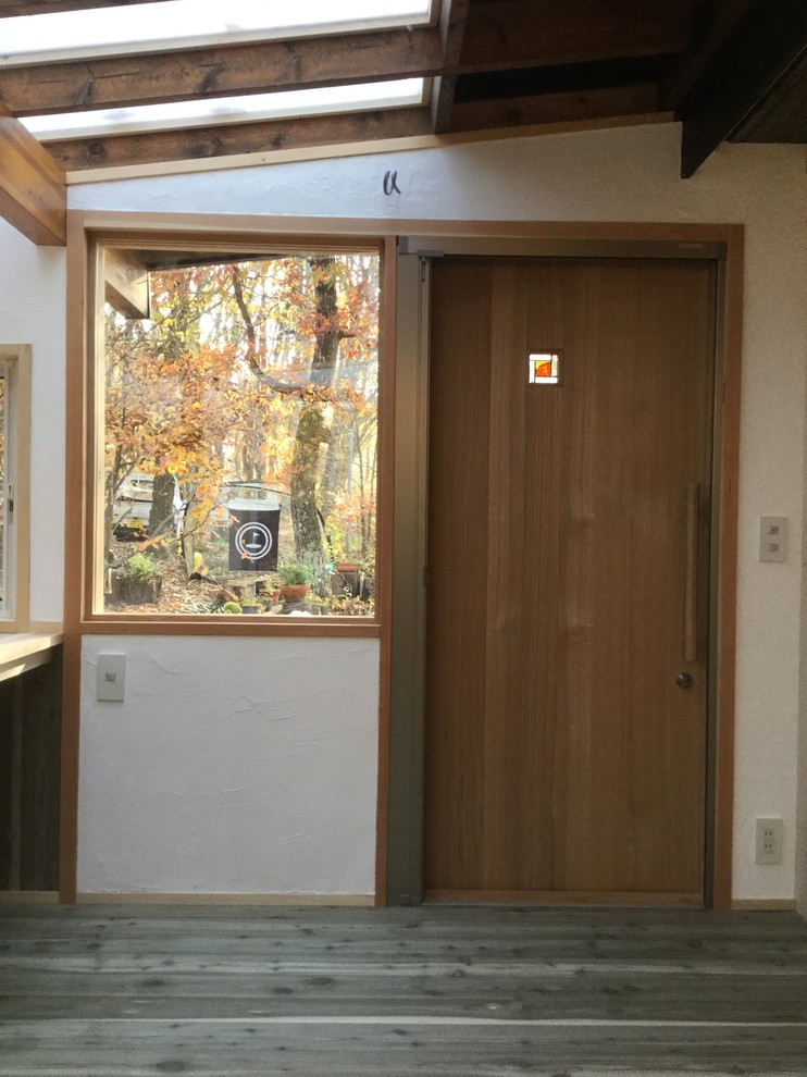他の地域にある高級な中くらいなアジアンスタイルのおしゃれな玄関ドア (白い壁、濃色無垢フローリング、木目調のドア) の写真