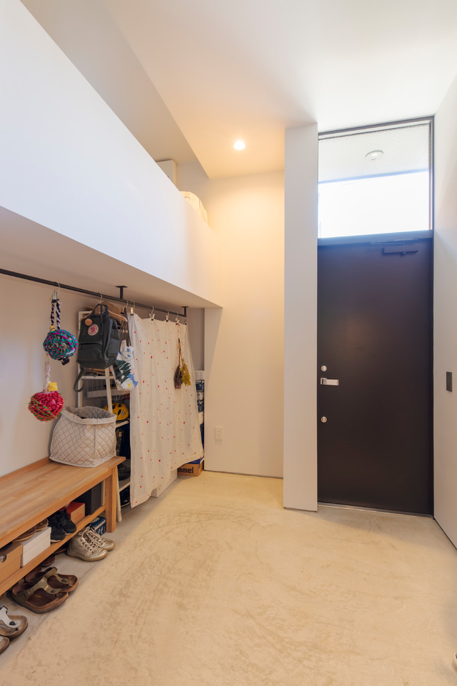 東京23区にあるエクレクティックスタイルのおしゃれなマッドルーム (白い壁、黒いドア、白い床) の写真