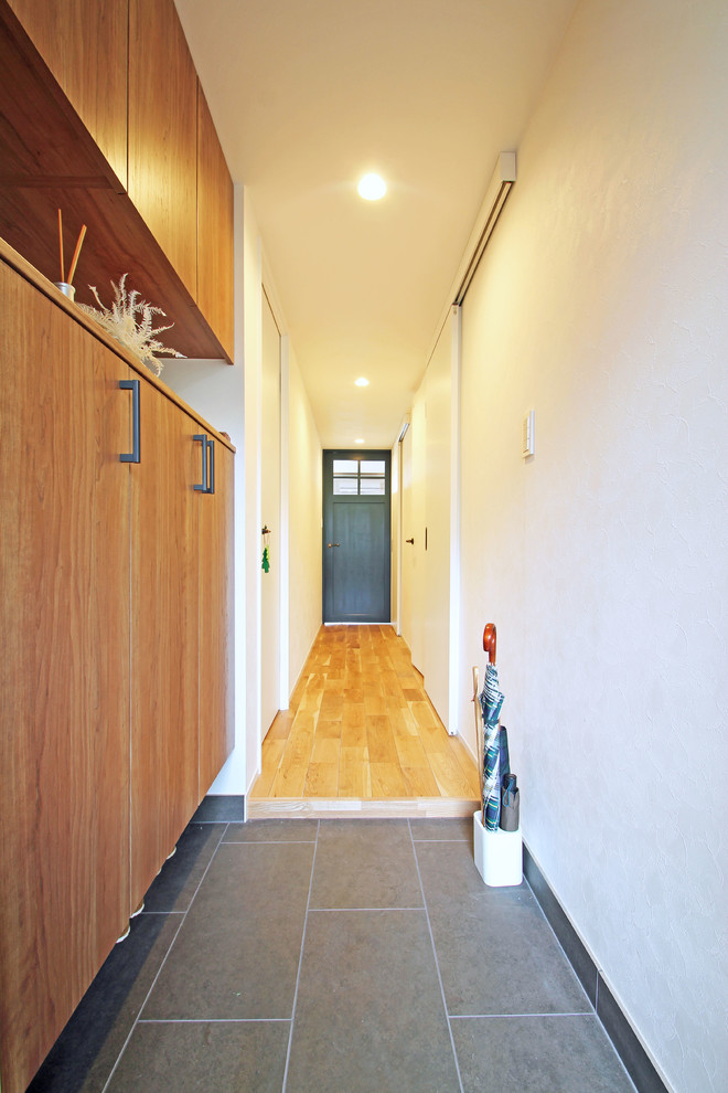 Idées déco pour une entrée scandinave avec un couloir, un mur blanc, un sol en carrelage de porcelaine et un sol gris.