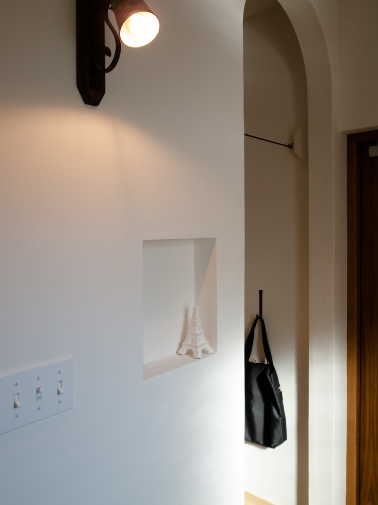 他の地域にある高級な広いカントリー風のおしゃれなマッドルーム (白い壁、テラコッタタイルの床、濃色木目調のドア、茶色い床) の写真