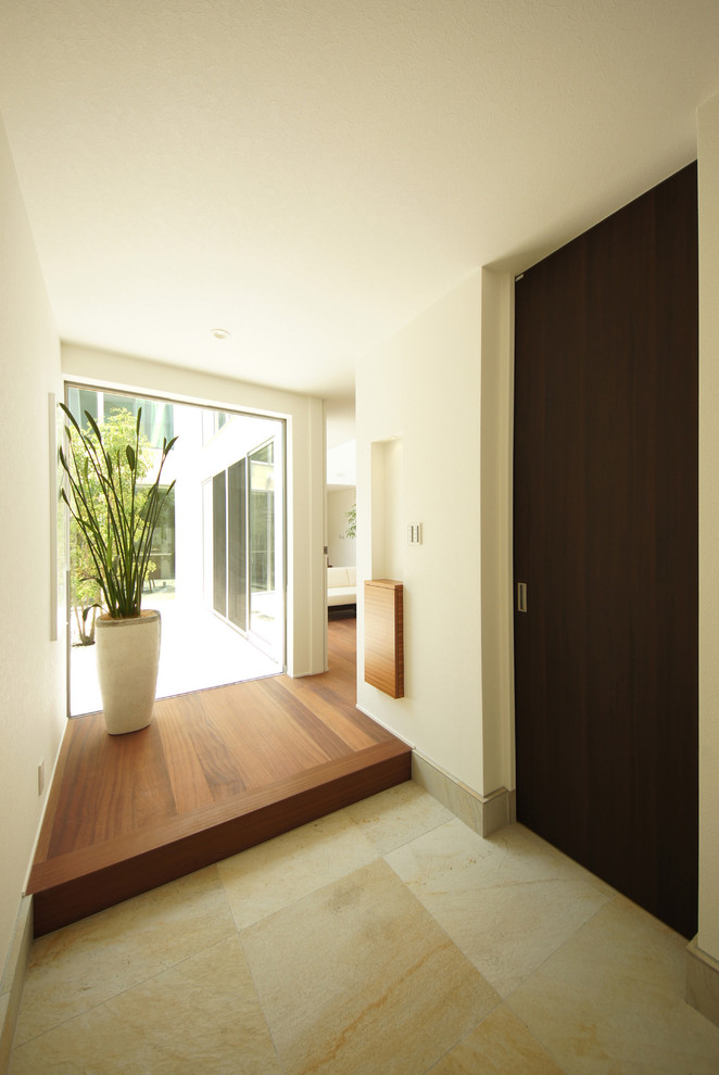 Ispirazione per un ingresso con vestibolo moderno di medie dimensioni con pareti bianche e pavimento in travertino
