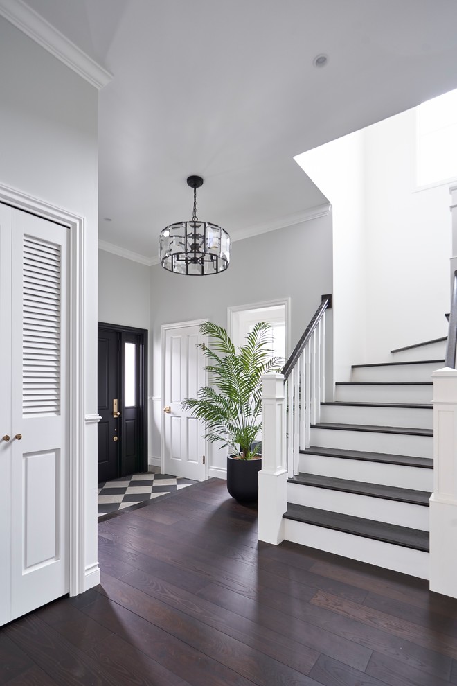 Idée de décoration pour une entrée design avec un couloir, un mur blanc, parquet foncé, une porte simple, une porte noire et un sol marron.