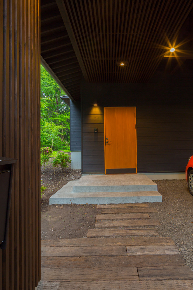 Mittelgroße Asiatische Haustür mit schwarzer Wandfarbe, Betonboden, Einzeltür, heller Holzhaustür und grauem Boden in Sonstige