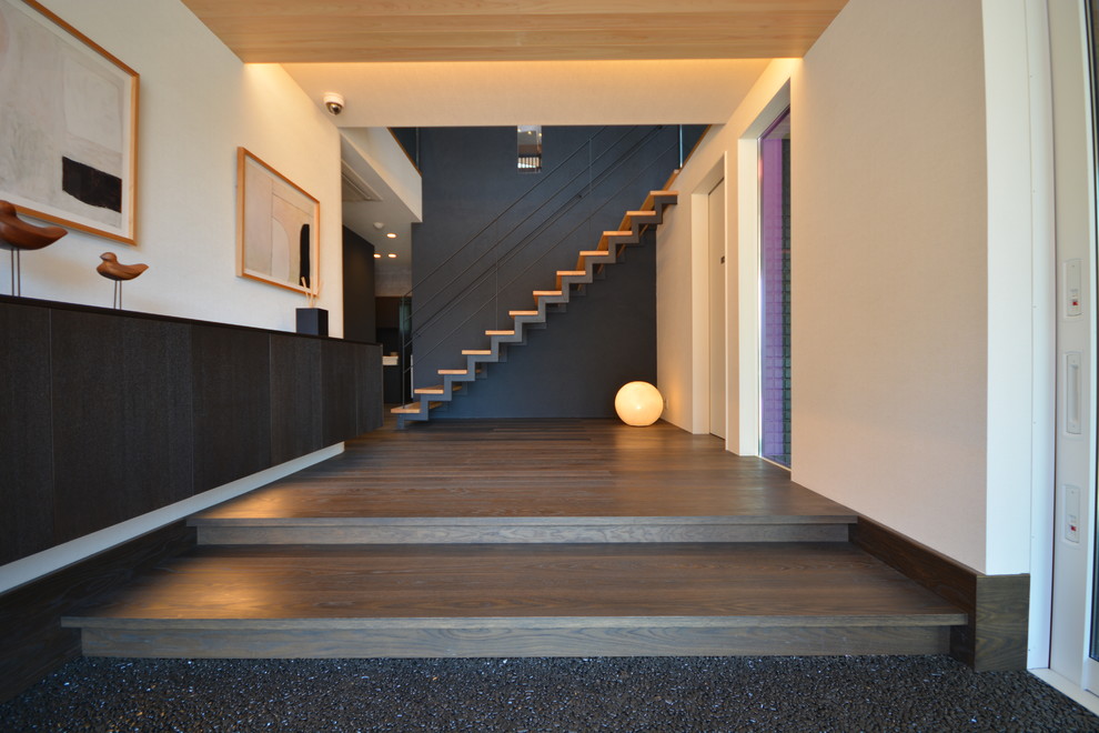 Diseño de hall de estilo zen con paredes blancas, suelo de contrachapado y suelo negro