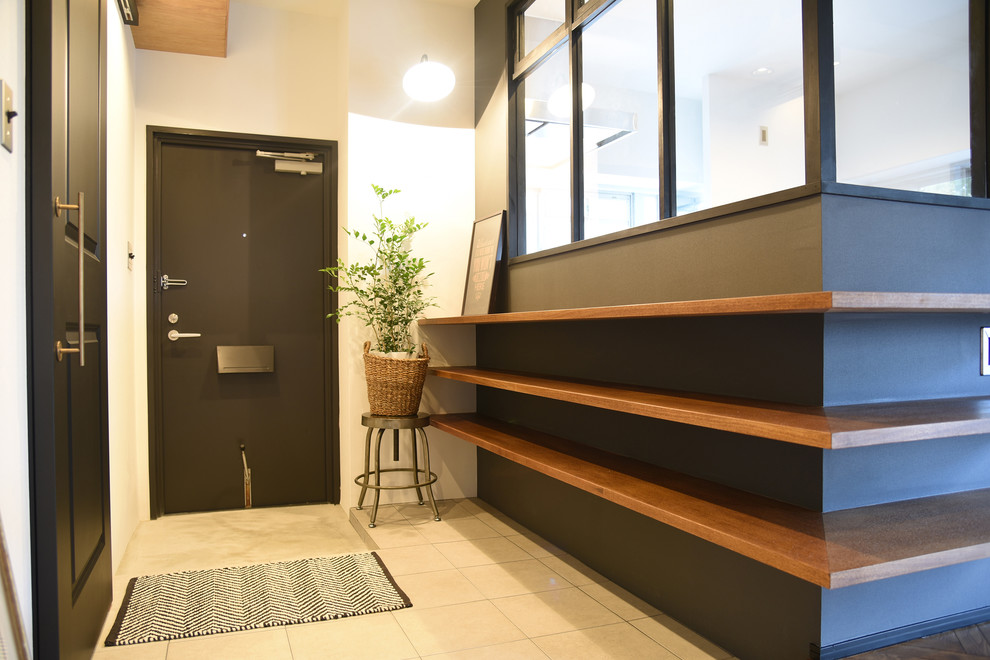 Ejemplo de entrada urbana con paredes blancas, puerta simple, puerta negra y suelo beige