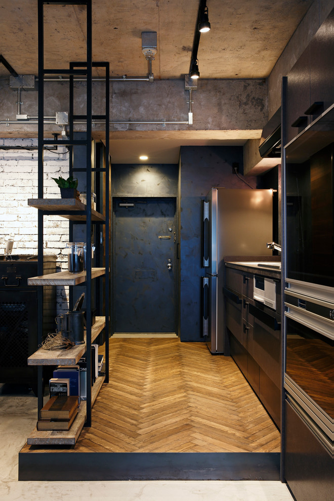 Industrial Eingang mit Korridor, grauer Wandfarbe, braunem Holzboden, Einzeltür und schwarzer Haustür in Tokio Peripherie
