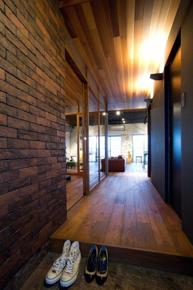 Aménagement d'une entrée industrielle de taille moyenne avec un couloir, un mur noir, un sol en vinyl et un sol noir.