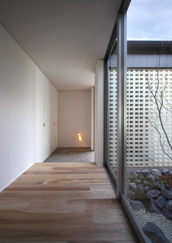 Свежая идея для дизайна: маленькая узкая прихожая в скандинавском стиле с белыми стенами, светлым паркетным полом, одностворчатой входной дверью и входной дверью из дерева среднего тона для на участке и в саду - отличное фото интерьера