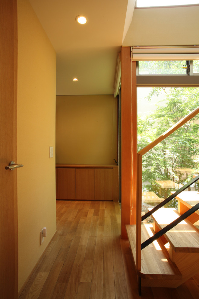 Пример оригинального дизайна: узкая прихожая среднего размера в стиле модернизм с белыми стенами, паркетным полом среднего тона, одностворчатой входной дверью, входной дверью из темного дерева и коричневым полом