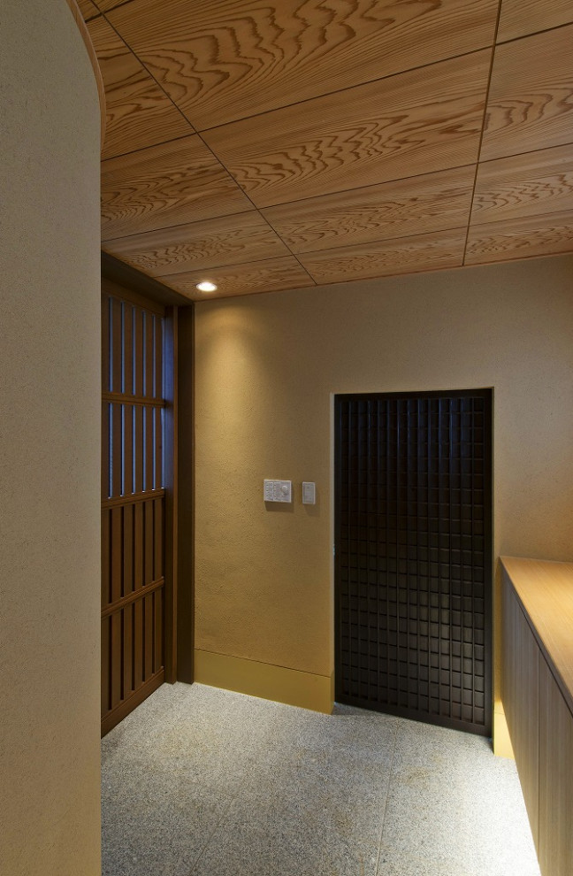 東京23区にある中くらいなトラディショナルスタイルのおしゃれな玄関ホール (ベージュの壁、御影石の床、濃色木目調のドア、ピンクの床、板張り天井) の写真