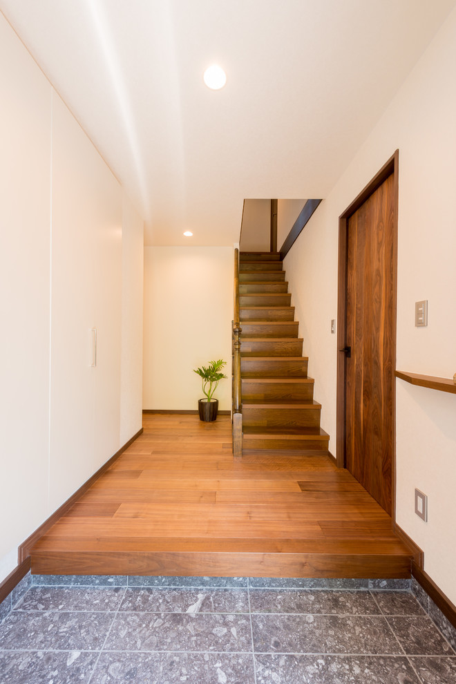 Idee per un corridoio minimalista con pareti bianche, parquet scuro, una porta singola, una porta nera e pavimento marrone