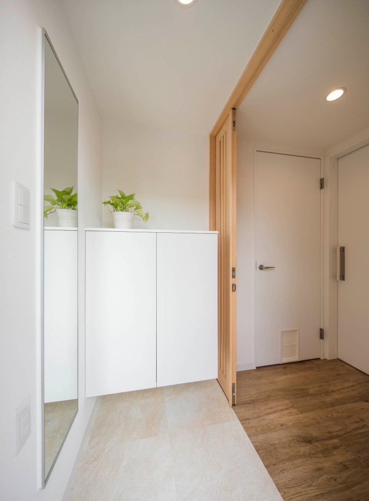 Foto på en mellanstor minimalistisk hall, med vita väggar, klinkergolv i keramik, en enkeldörr, en grå dörr och vitt golv