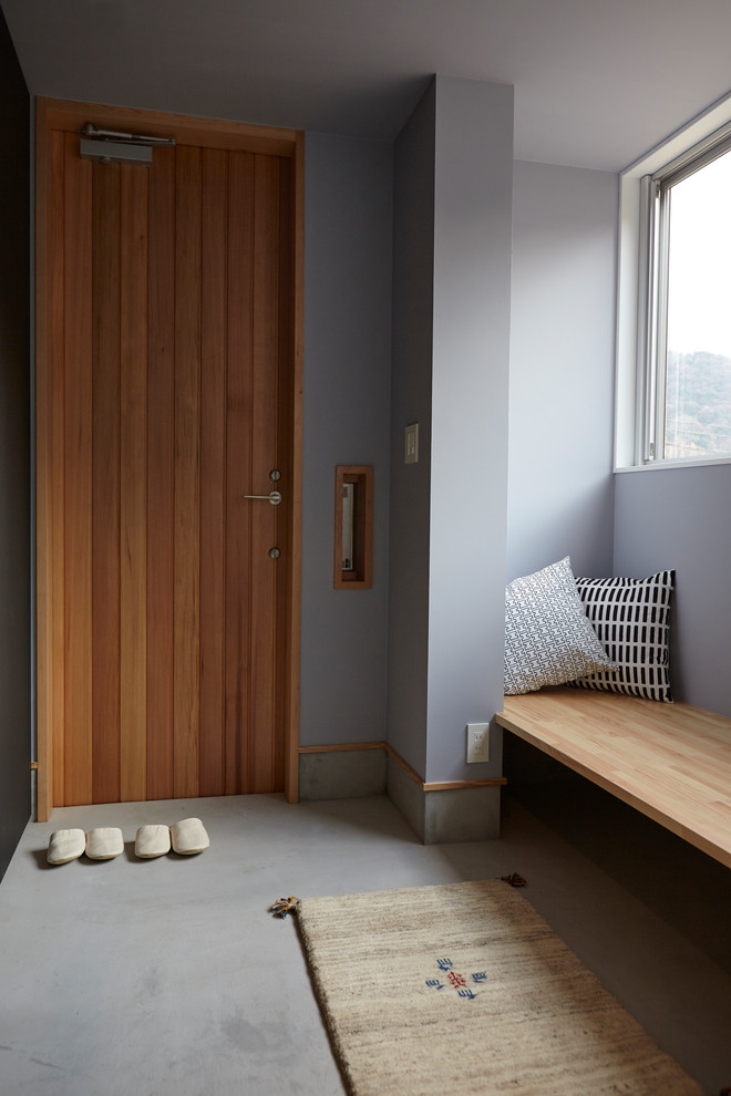 Ejemplo de hall gris escandinavo de tamaño medio con paredes grises, puerta simple, puerta de madera en tonos medios y suelo gris