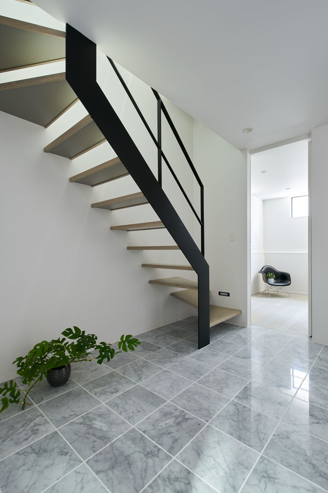 Moderne Haustür mit weißer Wandfarbe, Marmorboden, Einzeltür, schwarzer Haustür und grauem Boden in Tokio