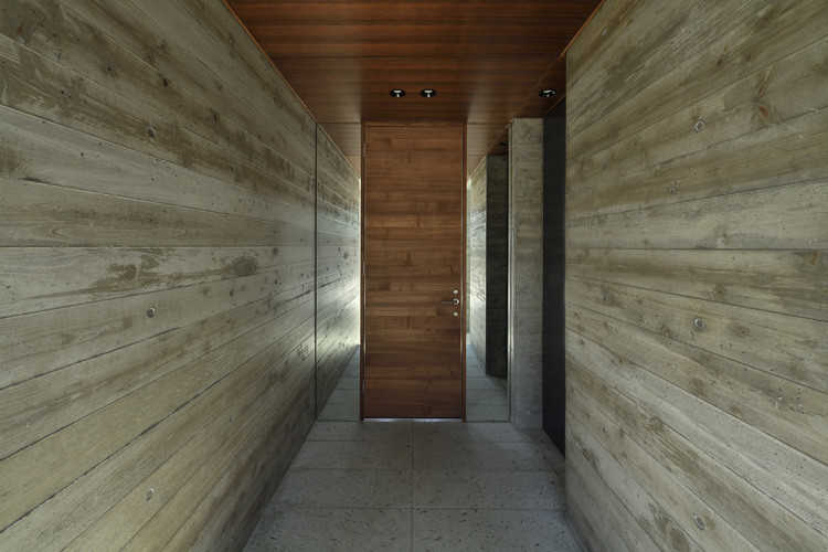 Idée de décoration pour une entrée avec un mur gris, une porte simple et une porte en bois foncé.