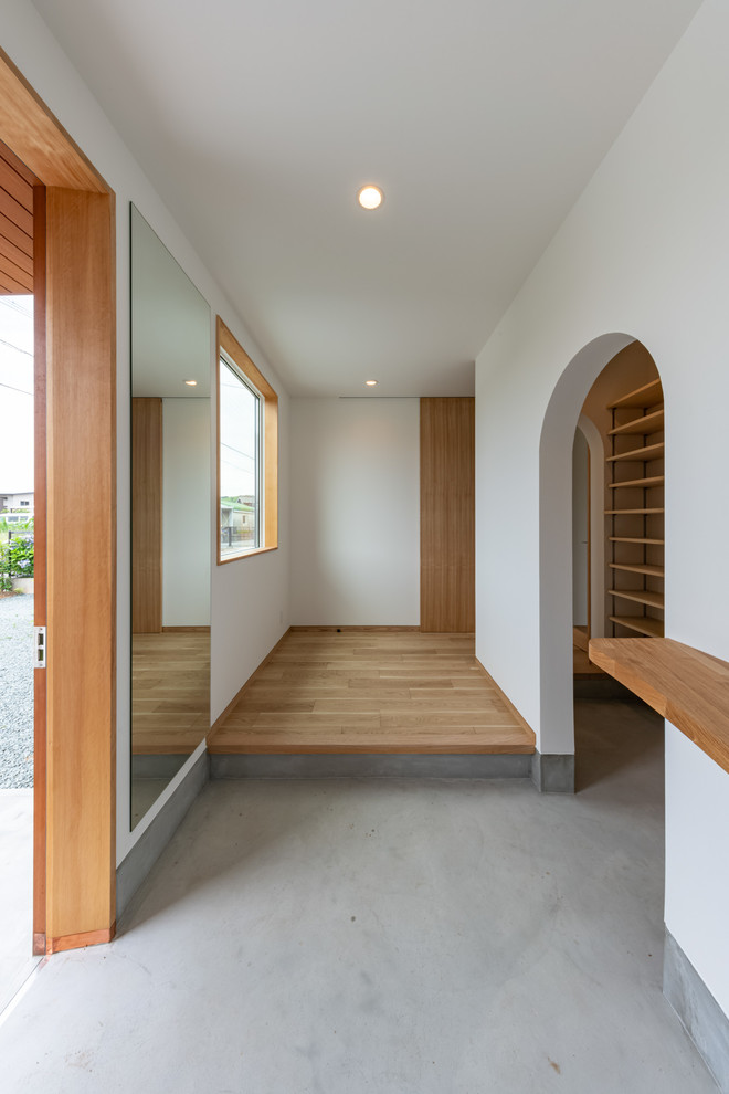 Cette photo montre une entrée scandinave de taille moyenne avec un couloir, un mur blanc, un sol en contreplaqué, une porte simple, une porte en bois brun, un plafond en papier peint, du papier peint et un sol marron.