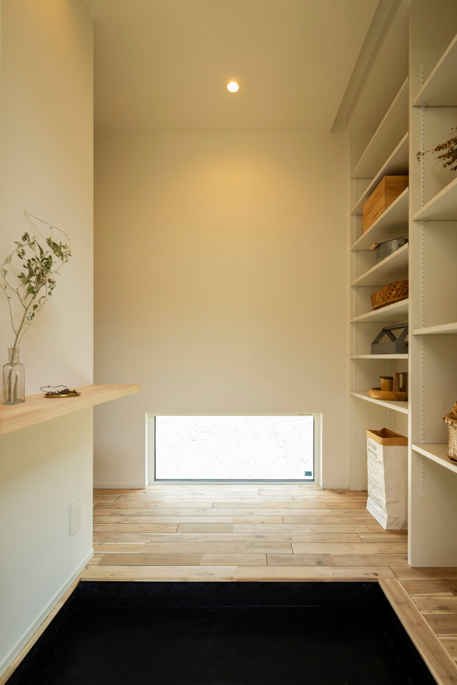 Aménagement d'une petite entrée montagne avec un couloir, un mur blanc, une porte simple, une porte noire, un plafond en papier peint et du papier peint.