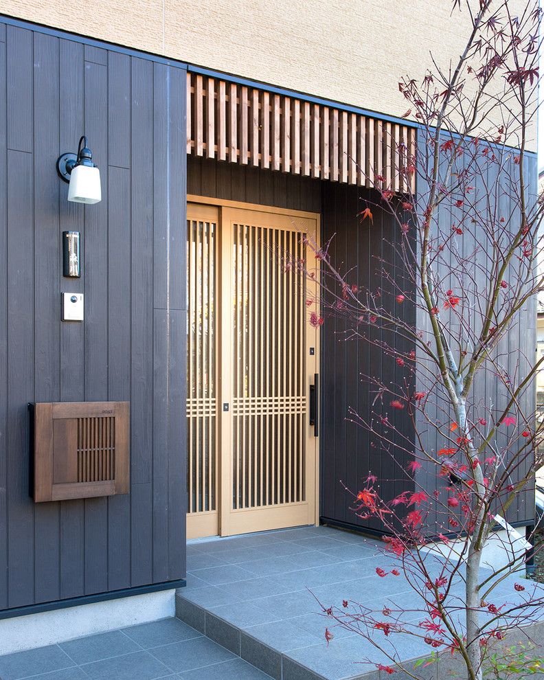 Свежая идея для дизайна: входная дверь в восточном стиле с черными стенами, одностворчатой входной дверью, входной дверью из светлого дерева и серым полом - отличное фото интерьера