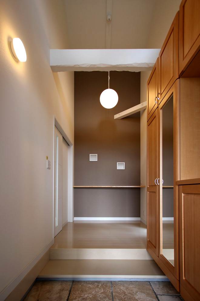 Cette image montre une entrée minimaliste de taille moyenne avec un mur blanc, un sol en contreplaqué, un couloir et un sol blanc.