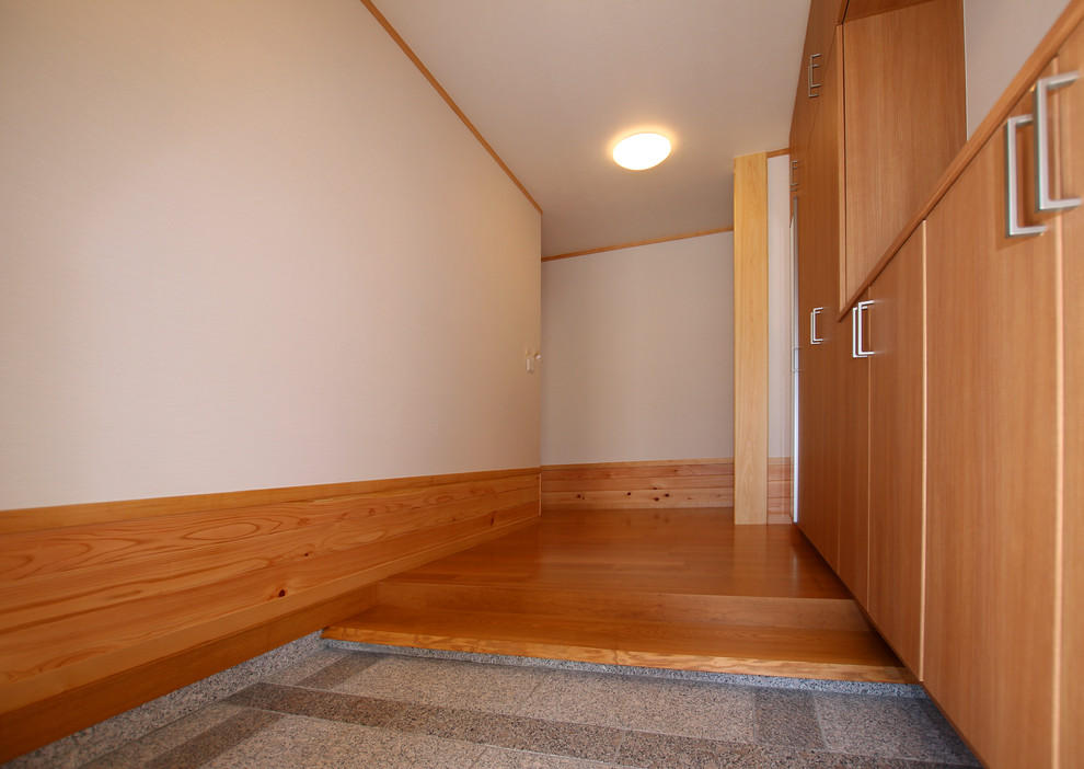 Inspiration pour une petite entrée minimaliste avec un mur blanc, un sol en contreplaqué, un couloir et un sol marron.