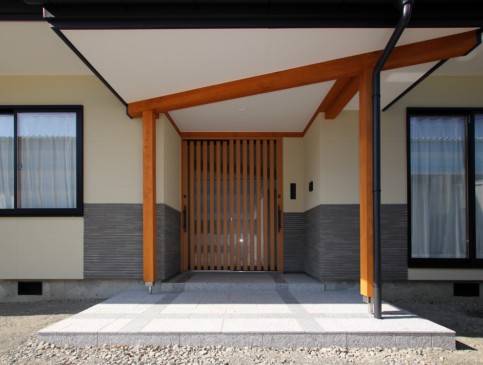 Aménagement d'une petite porte d'entrée asiatique avec un mur blanc, sol en granite, une porte en bois brun et un sol gris.