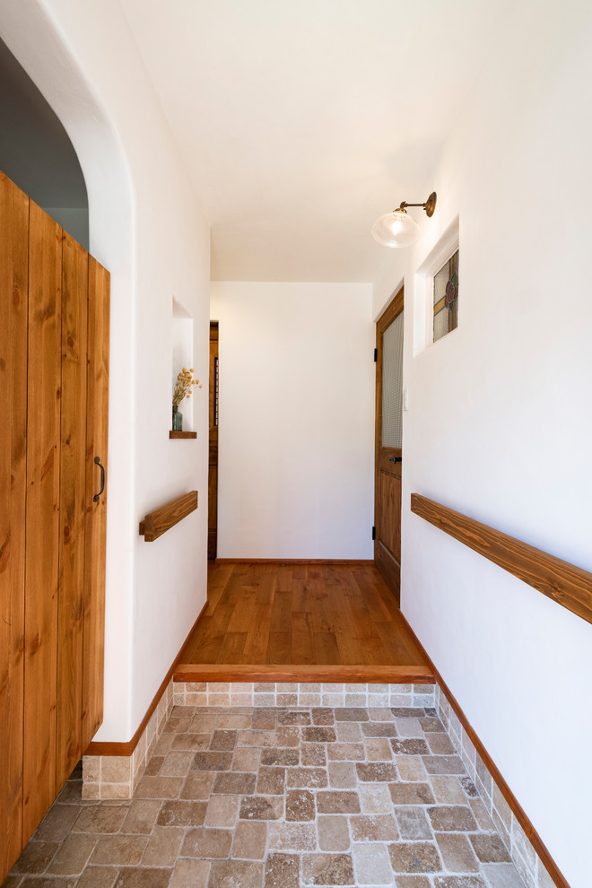 Design ideas for a medium sized world-inspired hallway in Other with white walls, dark hardwood flooring, a single front door, a medium wood front door and brown floors.