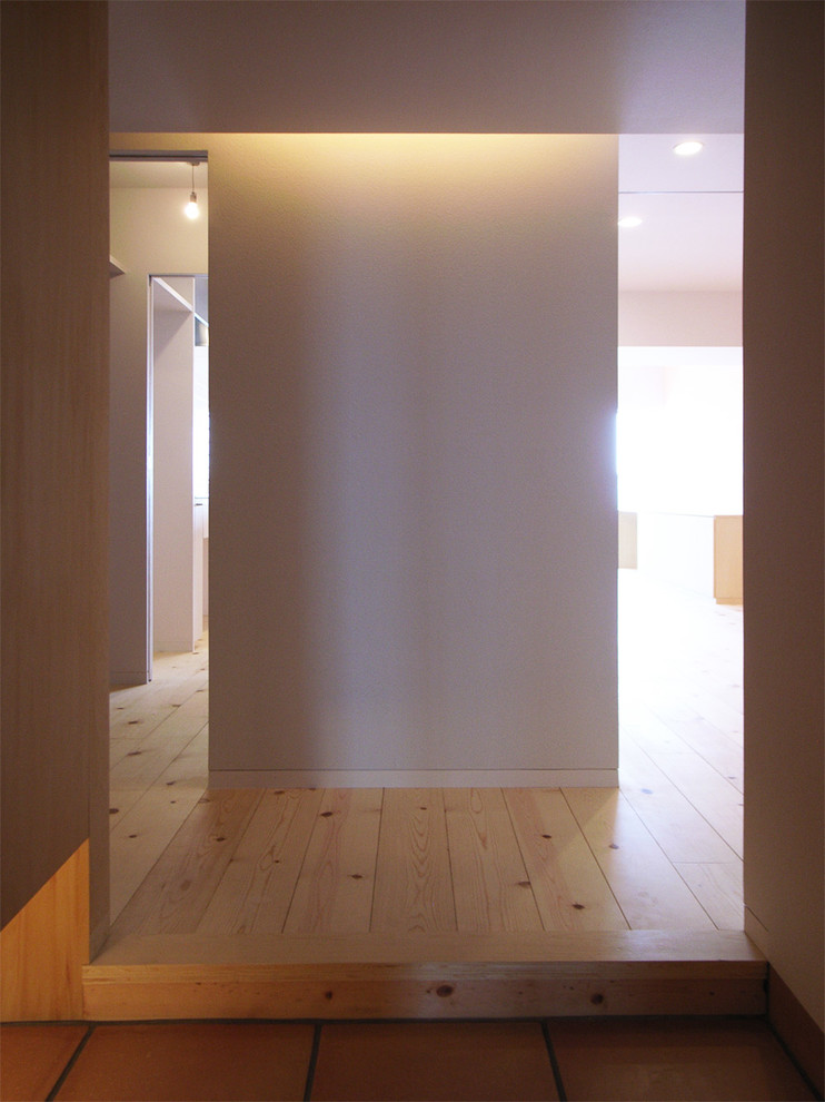 Design ideas for a scandinavian hallway in Tokyo with white walls and terracotta flooring.