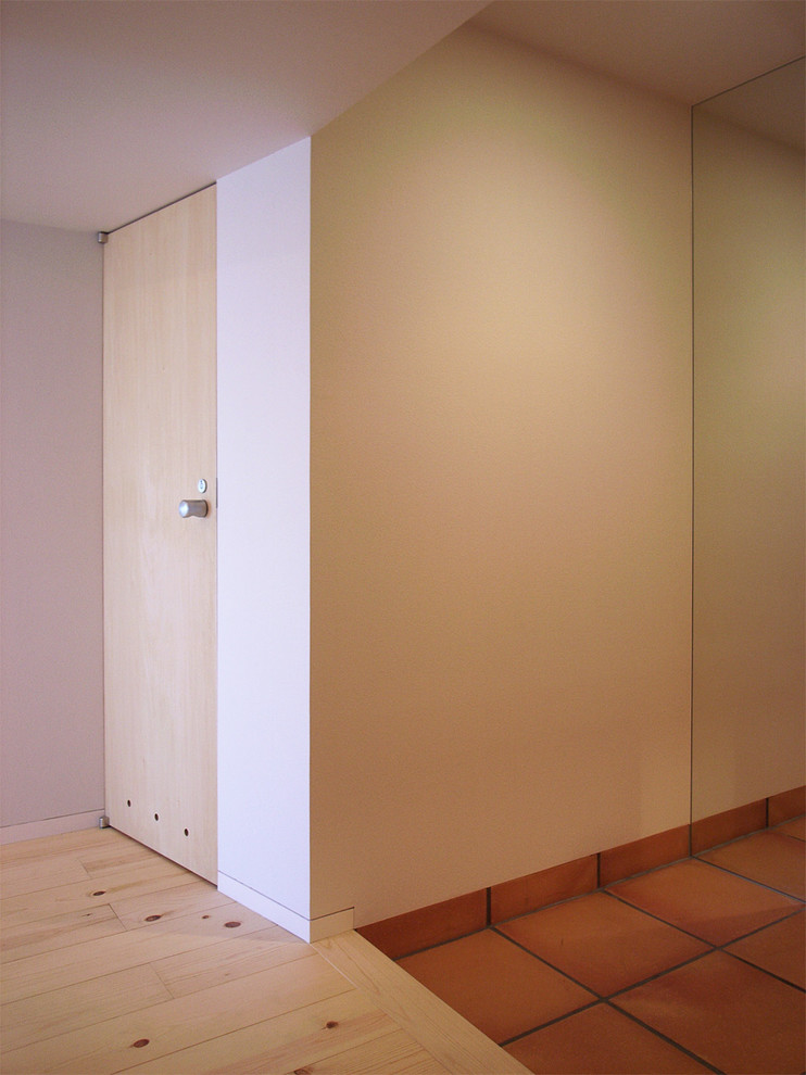 Ejemplo de hall escandinavo con paredes blancas y suelo de baldosas de terracota