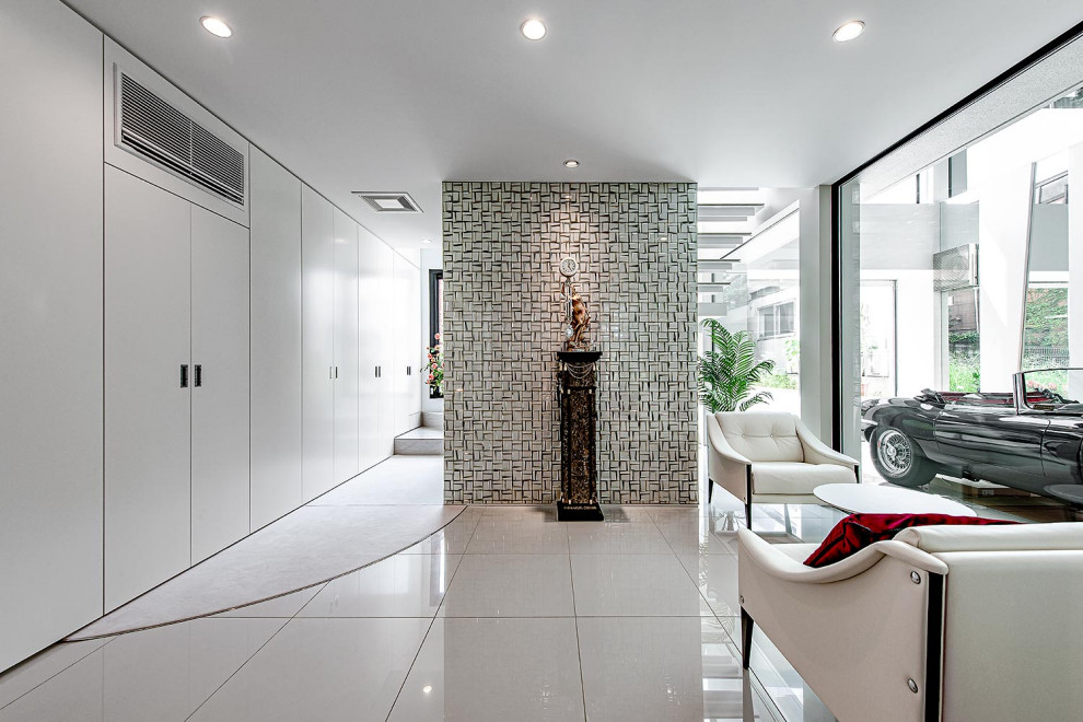 Idée de décoration pour une entrée minimaliste avec un couloir, un mur blanc, une porte double, une porte métallisée et un sol blanc.