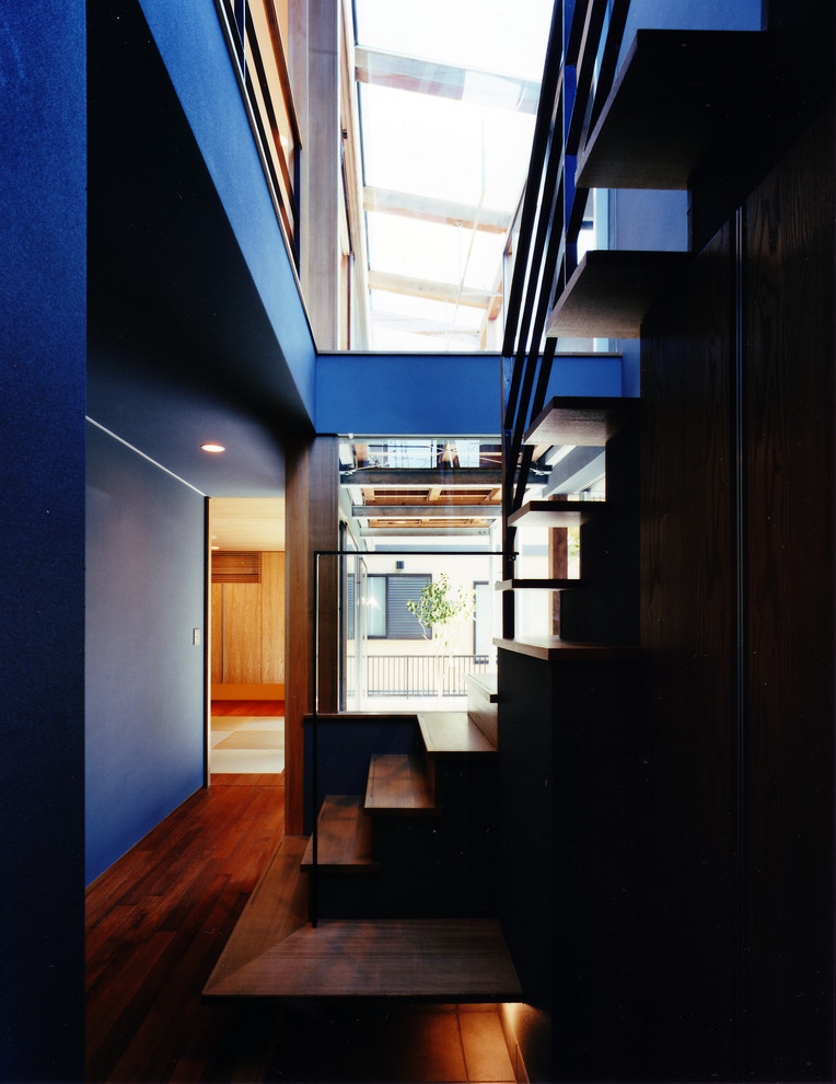 Пример оригинального дизайна: узкая прихожая среднего размера в стиле модернизм с серыми стенами, полом из терракотовой плитки, одностворчатой входной дверью, входной дверью из дерева среднего тона и серым полом