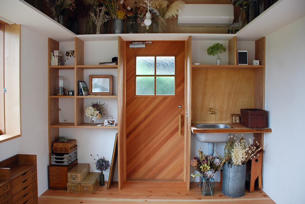 Imagen de puerta principal campestre con paredes blancas, suelo de madera en tonos medios, puerta simple, puerta marrón y suelo marrón